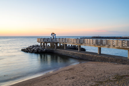 Pier cross over the sea at sunsetの写真素材