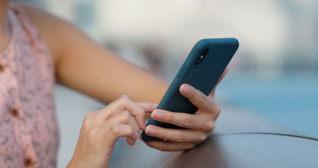 Close up of woman use of smart phone at outdoorの写真素材