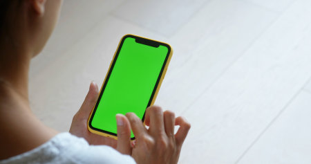 Woman use of cellphone with green screen at homeの写真素材