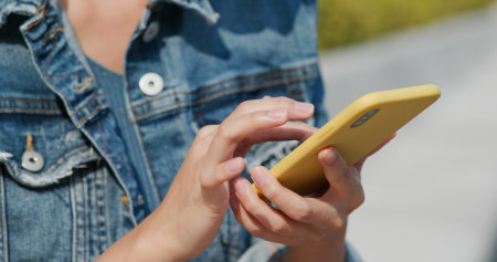 Woman use of mobile phone in city at outdoorの写真素材