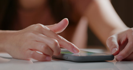 Woman use of cellphone on tableの写真素材