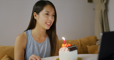 Woman celebrate birthday and make video call on tablet computer at homeの写真素材