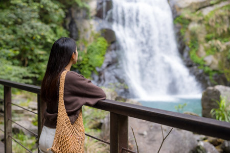 Woman look at the beautiful waterfallの写真素材