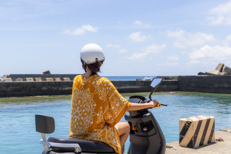 Travel Woman ride a motor bike at seaside