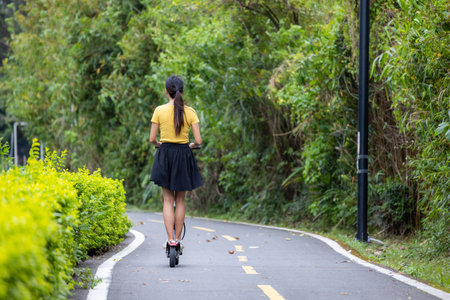 Woman play with motor scooter in parkの写真素材