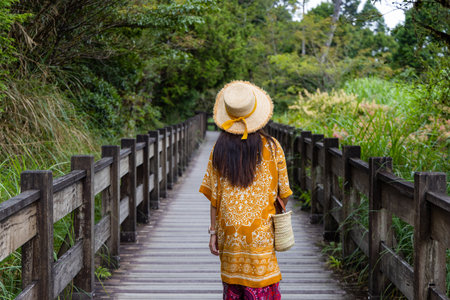 Travel woman walk on the wooden path in forest