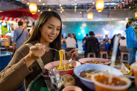 Woman enjoy her Thai noodle at Thai restaurant