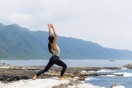 Woman practicing yoga on the beach