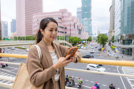 Woman use mobile phone in Taipei cityの写真素材