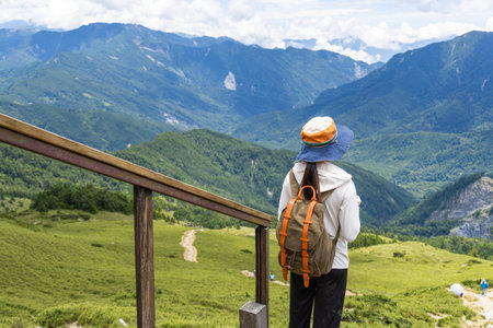 Hiking woman stand on the top of the peakの写真素材