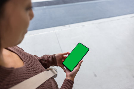 Woman hold with green screen of mobile phone at outdoorの写真素材
