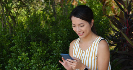 Woman use mobile phone with the green background