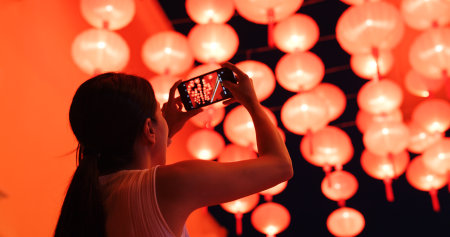 Woman take photo on cellphone with the red lanternの写真素材