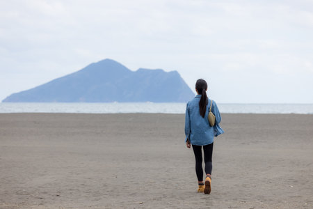 Woman walk along the sand beach in Yilan of Taiwanの写真素材