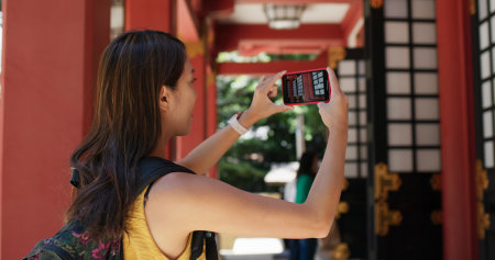 Woman take photo on cellphone in japanese templeの写真素材