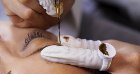 Beautician specialist of permanent makeup making brow microblading tattooing make upの写真素材