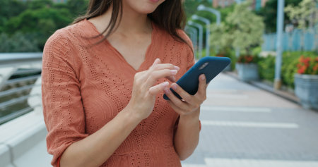 Close up of woman use of mobile phone at outdoorの写真素材