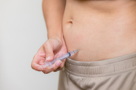 Woman injects hormones into the belly with a syringeの写真素材