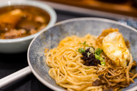 Spicy noodles with fried egg and mushroomの写真素材