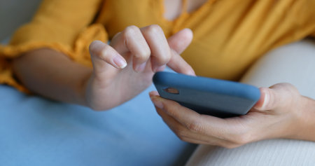 Woman use mobile phone at homeの写真素材
