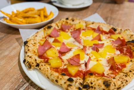 Tropical Hawaiian pizza with pineapple slices and hamの写真素材
