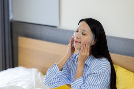 Woman apply the facial mask on face at homeの写真素材