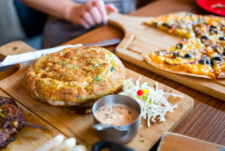 Egg omelette serve over the wooden plate in restaurant