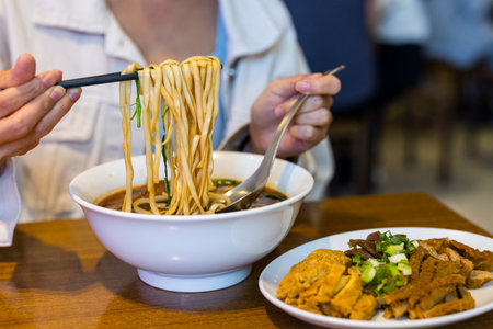 Woman enjoy the Taiwanese beef noodle soupの写真素材