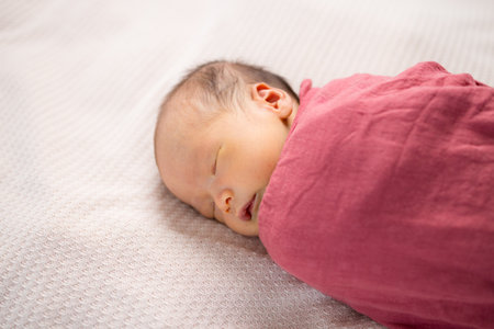 Adorable baby boy sleep on bedの写真素材