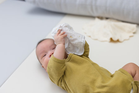 Newborn baby holding cloth on soft matの写真素材