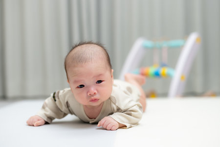 Newborn baby lift his head on the play mat at two months periodの写真素材
