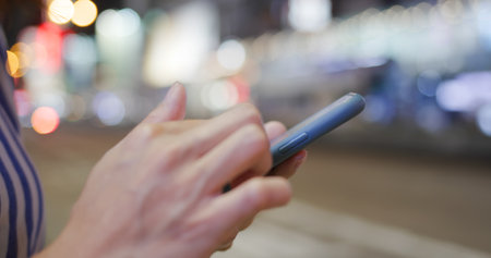 Woman use smart phone in city at night