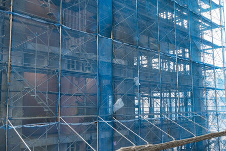 Tall building with blue wall safety netの写真素材