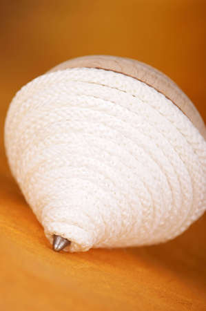 A peg top with white cord. Selective focus, extremely shallow DOF.