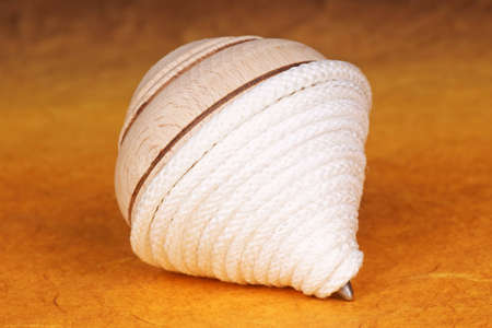 A peg top with white cord. Selective focus, shallow DOF.