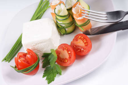 Cream cheese, Piccadilly tomatoes, zucchini and carrot rolls with cream cheese finely disposed on a squared white plate.の写真素材