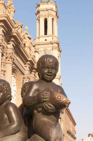 Detail of a bronze fountain in Plaza del Pilar and "Basilica de Nuestra Senora del Pilar" in the backgroundのeditorial素材