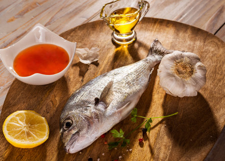 fish with vegetables on a stone slateの写真素材