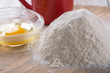 Ingredients for cooking baking - flour, egg, cookie cutters on wooden board.の写真素材