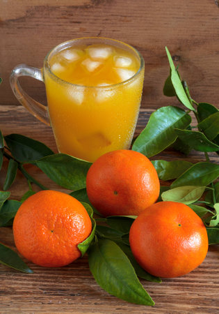 The mandarins and tangerine juice on a wooden backgroundの写真素材
