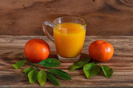 The mandarins and tangerine juice on a wooden backgroundの写真素材