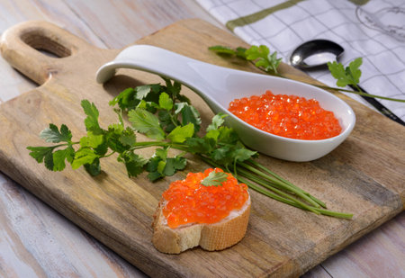 Sandwich with red caviar on a wooden cutting boardの写真素材