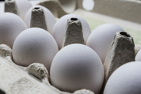 white chicken eggs in a cardboard boxの写真素材