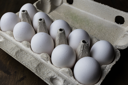 white chicken eggs in a cardboard boxの写真素材