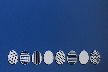 Easter eggs cut from paper on a classic blue backgroundの写真素材