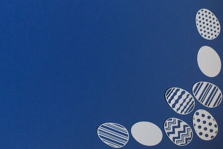 Easter eggs cut from paper on a classic blue backgroundの写真素材