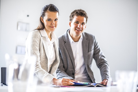 Portrait of business people working at desk in officeの写真素材