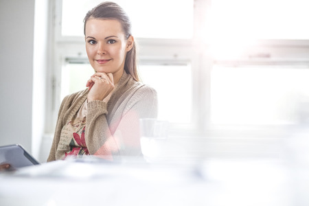 Portrait of young businesswoman using digital tablet in officeの写真素材