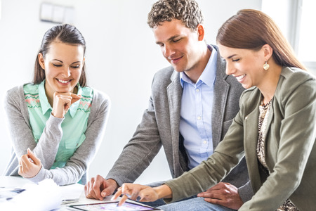 Young businessman with female colleagues using digital tablet in officeの写真素材
