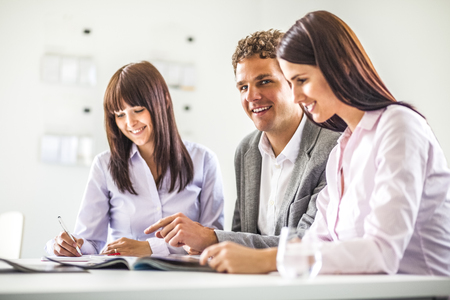 Young businessman having discussion with female colleagues in creative officeの写真素材